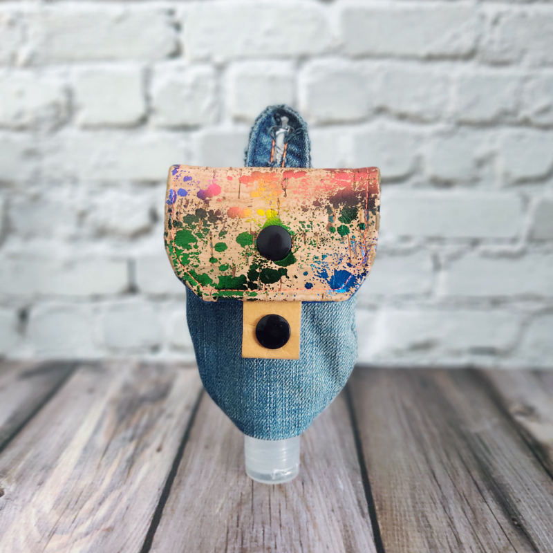 Frontansicht einer Upcycling-Tasche für Desinfektionsmittel, genäht aus alter Jeans und neuem Korkstoff. Die Tasche ist mit einem schwarzen Druckknopf geschlossen.