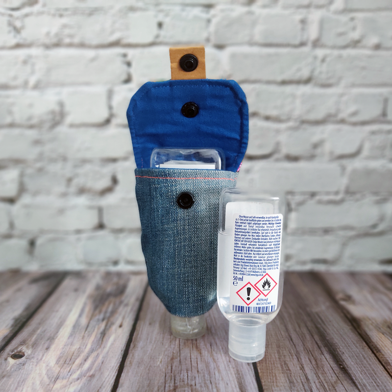 Desinfektionsmittel-Tasche im Jeans-Look mit geöffnetem Verschluss. So dass man in die Tasche schauen kann. Das Innenfutter ist dunkelblau.
